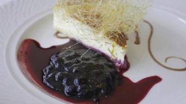 Bir parça peynirli keki beyaz tabakta yaban mersini sosuyla kapat.