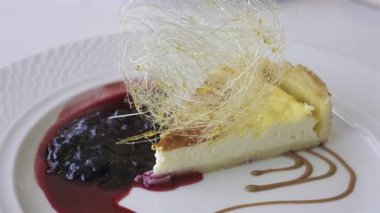 Bir parça peynirli keki beyaz tabakta yaban mersini sosuyla kapat.