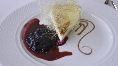 Bir parça peynirli keki beyaz tabakta yaban mersini sosuyla kapat.