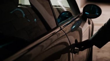 Otoparkın kapısını açan ve kapatan bir kadının elini kapat.