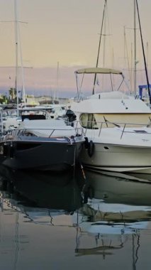 Antibes, Fransa 'da gün batımında Vauban Limanı' na çok sayıda beyaz tekne yanaştı. Dikey
