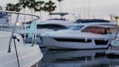 Fransa 'nın Antibes şehrinde gün batımında Vauban Limanı' na yanaşan çok sayıda beyaz teknenin bulanık görüntüsü