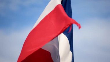 Arka planda mavi bir gökyüzü ile rüzgarda dalgalanan Fransa bayrağını kapatın.