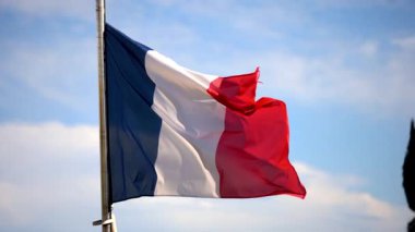 Arka planda mavi bir gökyüzü ile rüzgarda dalgalanan Fransa bayrağını kapatın.