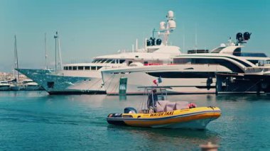 Antibes, Fransa - 10 Mayıs 2025: Sarı su taksisi gündüz vakti Vauban Limanı 'ndan geçiyor