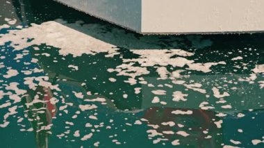 Bir platformdan mavi denize damlayan köpüğü kapat