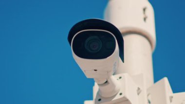 Mavi bir arka planda beyaz bir güvenlik kamerasını kapat.