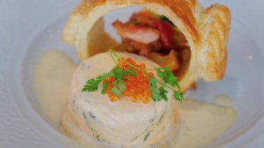 Somon yumurtası ve bir restoranda beyaz bir tabakta puf böreği olan bir balık kremasını kapat.