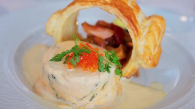 Somon yumurtası ve bir restoranda beyaz bir tabakta puf böreği olan bir balık kremasını kapat.