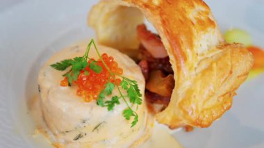 Somon yumurtası ve bir restoranda beyaz bir tabakta puf böreği olan bir balık kremasını kapat.