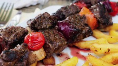 Restoranda ızgara domuz şiş, domates ve patates kızartması.