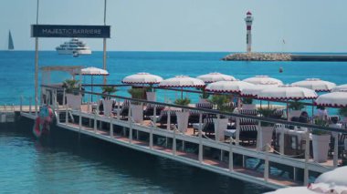 Cannes, Fransa - 13 Mayıs 2025: İnsanlar sahildeki terasta güneş şemsiyeleri altında dinleniyor