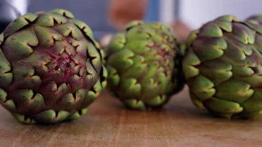 Tahta masadaki üç enginarı kapat.