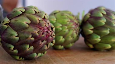 Tahta masadaki üç enginarı kapat.