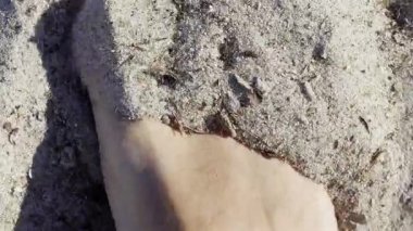 Sahilde kumsalda oynayan bir adamın ayağını kapat.