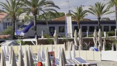 Antibes, Fransa - 23 Mayıs 2025: Akşamleyin sahilden geçen mavi tren