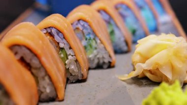 Üçgen şekilli somon suşisini wasabi ve gari ile kaplayın.