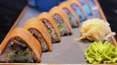 Üçgen şekilli somon suşisini wasabi ve gari ile kaplayın.