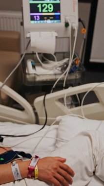 Hamile kadın, doğum öncesi muayenesi sırasında hastane yatağında uzanıyor. Dikey