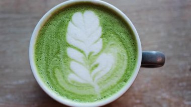 Ahşap bir masada bir kibrit latte yakın çekim