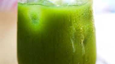 Bir kafedeki masada bir bardak buzlu portakal suyu eşleşmesi.