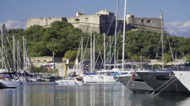 Antibes, Fransa - 7 Haziran 2025: Arka planda Fort Carre ile birlikte Vauban Limanı 'na çok sayıda beyaz tekne yanaştı