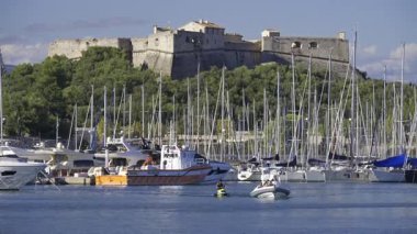 Antibes, Fransa - 7 Haziran 2025: Arka planda Fort Carre ile birlikte Vauban Limanı 'na çok sayıda beyaz tekne yanaştı