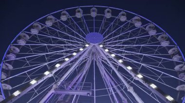 Akşamları Antibes, Fransa 'da dönen beyaz, aydınlık dönme dolap manzarası