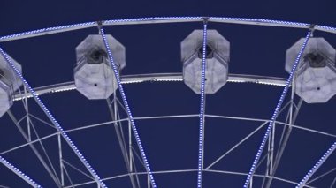 Akşamları Antibes, Fransa 'da dönen beyaz, aydınlık dönme dolap manzarası