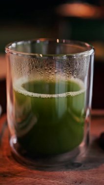 Masadaki bir bardak yeşil çayı kapat. Dikey