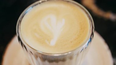 Camdan bir fincanı bir kafede latteyle kapat.