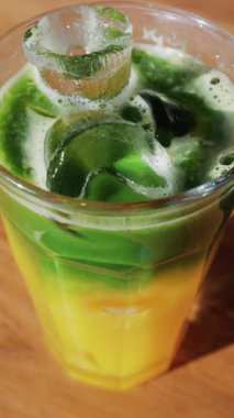 Kafedeki bir masada bir bardak buzlu portakal suyu eşleşmesi. Dikey