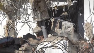 Chisinau, Moldova - 6 Haziran 2025: Hidrolik kırıcıyla beton binayı yıkan bir kazıcı