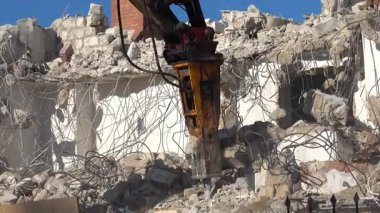 Chisinau, Moldova - 6 Haziran 2025: Hidrolik kırıcıyla beton binayı yıkan bir kazıcı