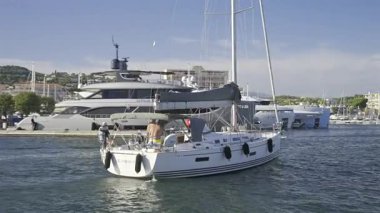 Cannes, Fransa - 22 Haziran 2025: Gündüz vakti Cannes Limanı 'ndan geçen bir teknede insanlar