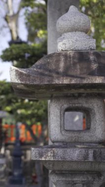 Huzurlu bir yerde, berrak gökyüzünün altında geleneksel taş fenerlerle huzurlu bir bahçeyi keşfetmek.