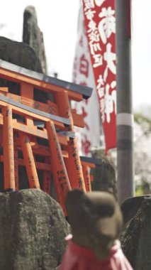 Kyoto, Japonya - 9 Nisan 2025: Parlak kırmızı torii kapıları ve geleneksel taş fenerlerin yer aldığı tarihi bir tapınakta sükunet deneyimi. Kyoto, Japonya, Fushimi Inari