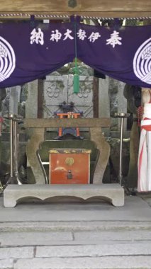 Kyoto, Japonya - 10 Nisan 2025: Mimari detayların ve renkli kumaş afişlerin sergilendiği türbe. 