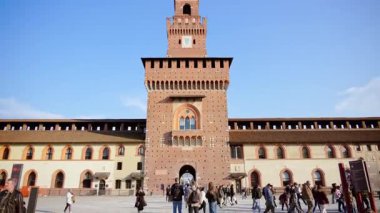 Milano, İtalya - 20 Mart 2025 Sforzesco Kalesi 'nde gündüz vakti Filarete Kulesi yakınlarında yürüyen insanlar