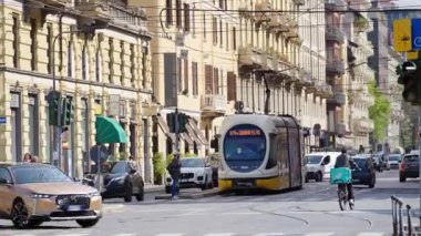 Milano, İtalya - 20 Mart 2025: İnsanlar, arabalar ve toplu taşımacılık şehrin sokaklarında gün ışığında hareket ediyor