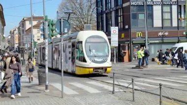 Milan, İtalya - 21 Mart 2025: Sarı tramvay güpegündüz şehrin sokaklarında hareket ediyor