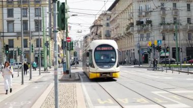 Milan, İtalya - 21 Mart 2025: Sarı tramvay güpegündüz şehrin sokaklarında hareket ediyor