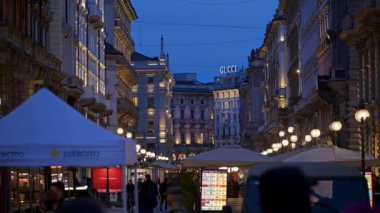 Milan, İtalya - 23 Mart 2025: İnsanlar akşamları bir sokak pazarında yürüyorlar