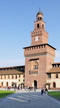 Milan, İtalya - 20 Mart 2025 Sforzesco Kalesi 'nde gündüz vakti Filarete Kulesi yakınlarında yürüyen insanlar. Dikey
