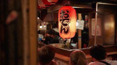 Shinjuku, Japonya - 12 Nisan 2025: İnsanlar Omoide Yokocho Memorory Lane 'de geleneksel bir Japon restoranında oturuyorlar. Çeviri: Izakaya