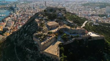 İspanya 'nın Alicante sahilindeki Santa Barbara Kalesi' nin arka planında şehir ve deniz olan insansız hava aracı görüntüsü.