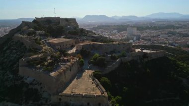 İspanya 'nın Alicante sahilindeki Santa Barbara Kalesi' nin arka planında şehir ve deniz olan insansız hava aracı görüntüsü.