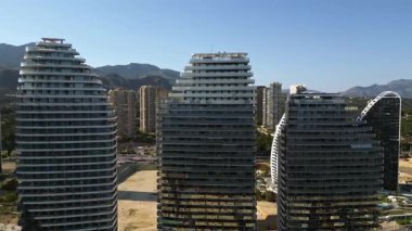 İspanya, Benidorm 'daki sahil şeridi boyunca gün ışığında binaların insansız hava aracı görüntüsü