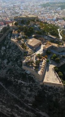 İspanya 'nın Alicante kıyısındaki Santa Barbara Kalesi' nin arka planında şehir olan insansız hava aracı görüntüsü. Dikey