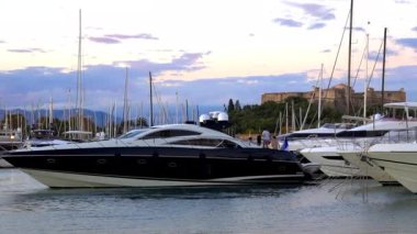 Antibes, Fransa - 2 Temmuz 2025: Arka planda Fort Carre ile birlikte Vauban Limanı 'na yanaşan siyah beyaz yat